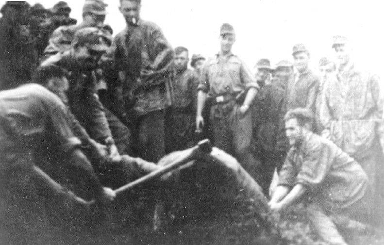 Ustasha men beating a victim with a club